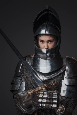 Téléchargez les photos : Isolé sur fond gris chevalier femelle du passé avec cotte et épée. - en image libre de droit