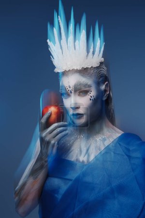 Téléchargez les photos : Photo studio de reine d'hiver avec peau gelée tenant pomme rouge. - en image libre de droit