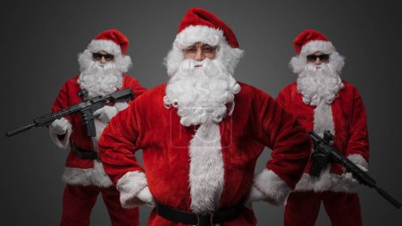 Photo for Portrait of isolated on gray background crew of three santa dressed in red costumes. - Royalty Free Image