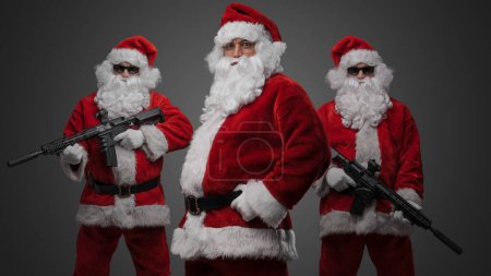 Photo for Portrait of isolated on gray background crew of three santa dressed in red costumes. - Royalty Free Image