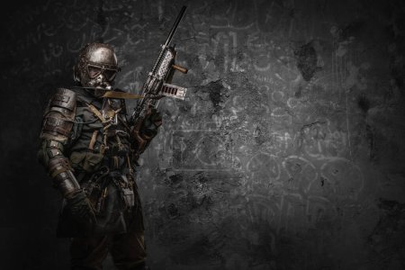 Photo for Shot of post apocalyptic soldier with uniform and shotgun dressed in armor and gas mask. - Royalty Free Image