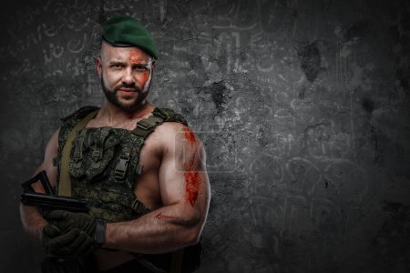 Téléchargez les photos : Portrait of soldier with muscular build holding handgun dressed in vest. - en image libre de droit