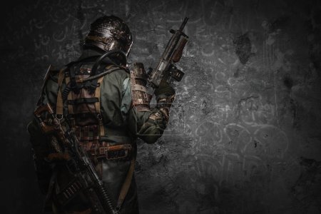 Photo for Shot of military man dressed in gas mask and ragged uniform with shotgun. - Royalty Free Image
