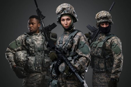 Téléchargez les photos : Portrait de trois soldats vêtus d'uniformes de camouflage tenant des fusils. - en image libre de droit