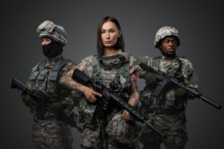 Photo for Portrait of team of three army soldiers dressed in camouflage suits holding rifles. - Royalty Free Image