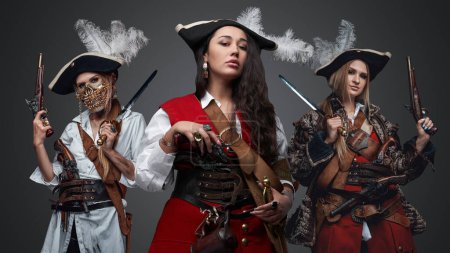 Foto de Shot of attractive female buccaneers dressed in antique attire with flintlock guns. - Imagen libre de derechos