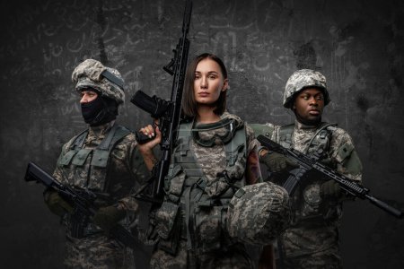 Foto de Shot of multiethnic squad of soldiers dressed in modern uniforms armed with rifles. - Imagen libre de derechos