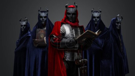 Retrato de miembros oscuros del culto vestidos con túnicas y su líder sosteniendo el libro.