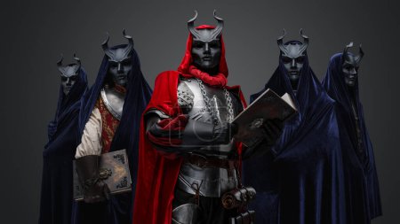 Foto de Retrato de miembros oscuros del culto vestidos con túnicas y su líder sosteniendo el libro. - Imagen libre de derechos