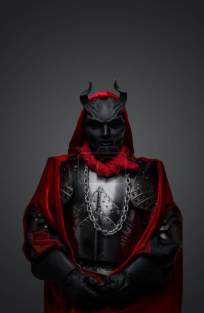 Foto de Retrato de miembro oscuro de misterioso culto vestido con túnica roja y máscara negra. - Imagen libre de derechos