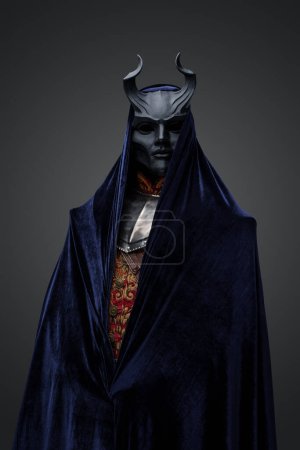 Téléchargez les photos : Studio shot of dark cultist dressed in black mask and dark cloak. - en image libre de droit
