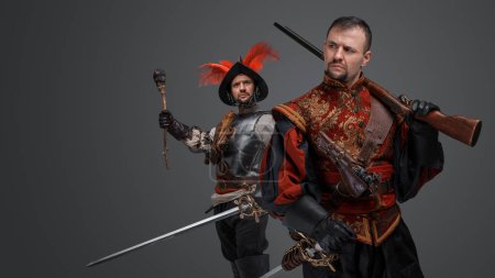 Téléchargez les photos : Portrait of isolated on gray background two conquistadors with rifle and torch. - en image libre de droit
