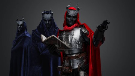 Foto de Retrato de dos miembros del culto esotérico y su líder sosteniendo el libro. - Imagen libre de derechos