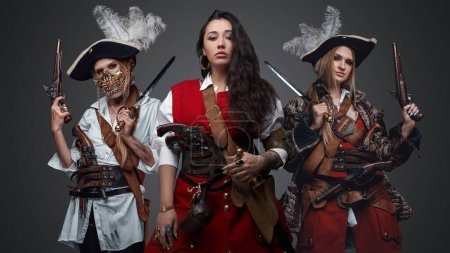Foto de Portrait of carribean pirates women dressed in stylish costumes holding handguns. - Imagen libre de derechos