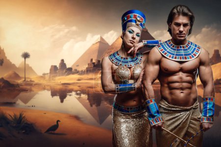 Foto de Artwork of graceful pharaoh woman with muscular man with naked torso near pyramids. - Imagen libre de derechos