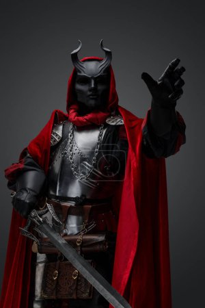 Téléchargez les photos : Shot of dark knight with plate armor and red robe armed with sword. - en image libre de droit