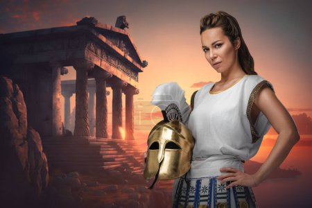 Photo for Art of warrior woman dressed in tunic holding plumed helmet around greek building. - Royalty Free Image
