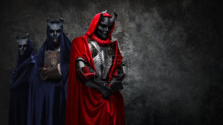Téléchargez les photos : Portrait of esoteric ogranization of three people dressed in robes and horned masks. - en image libre de droit