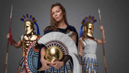 Foto de Portrait of three greek female warriors with spears and golden plumed helmets. - Imagen libre de derechos