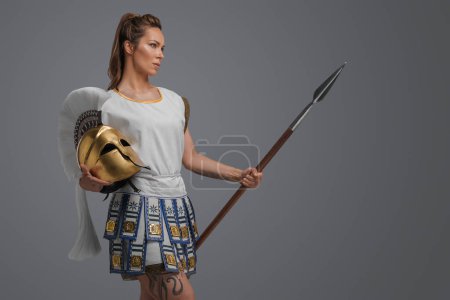 Téléchargez les photos : Portrait de soldat grec isolé sur fond gris femme avec lance. - en image libre de droit