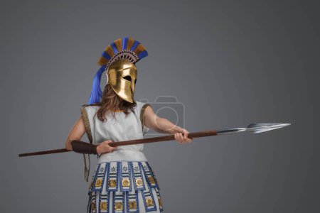 Foto de Shot of violent ancient female warrior with spear against grey background. - Imagen libre de derechos