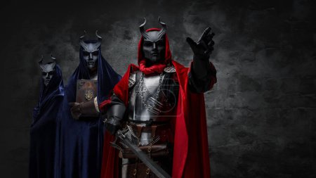 Téléchargez les photos : Studio shot of mysterious organization of three cultists dressed in robes and masks. - en image libre de droit