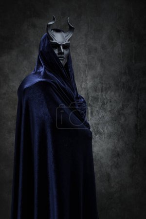 Photo for Studio shot of follower of dark cult dressed in dark robe and horned mask. - Royalty Free Image
