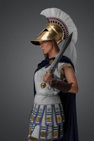 Téléchargez les photos : Studio shot of ancient greek general dressed in armor and holding gladius. - en image libre de droit