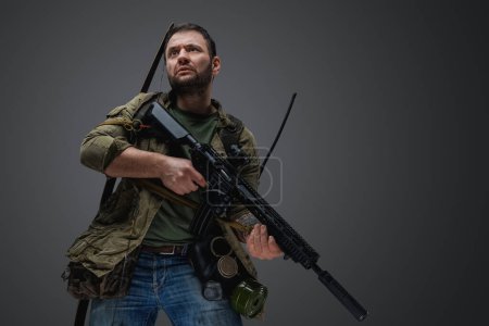 Photo for Portrait of man survivor in post apocalyptic style with gun and bow. - Royalty Free Image