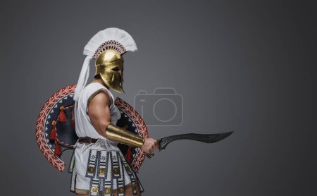 Téléchargez les photos : Portrait d'un soldat attaquant de la Grèce antique vêtu d'une tunique blanche et d'une armure. - en image libre de droit