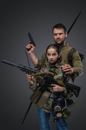 Photo for Studio shot of man survivor guarding little girl against grey background. - Royalty Free Image