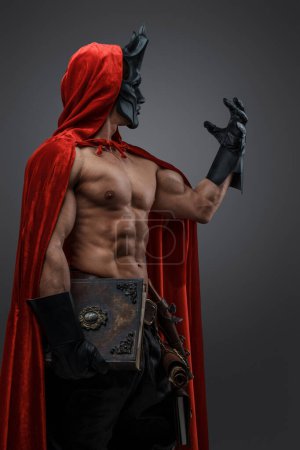 Photo for Shot of brawny cultist dressed in cloak and mask in spirit of dark fantasy. - Royalty Free Image