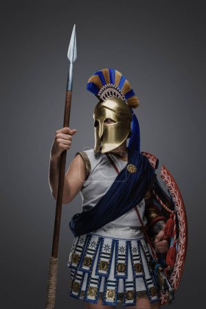 Photo for Portrait of warrior from antique greece dressed in tunic and golden helmet. - Royalty Free Image