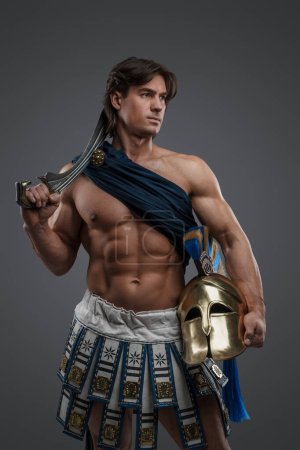 Shot of powerful warrior from greece with sword and plumed helmet.
