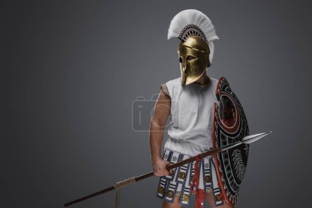 Foto de Estudio de tiro de soldado aislado sobre fondo gris de la antigua Grecia con escudo y lanza. - Imagen libre de derechos