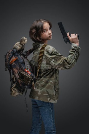 Foto de Portrait of young girl survived after global disaster dressed in camouflage jacket. - Imagen libre de derechos