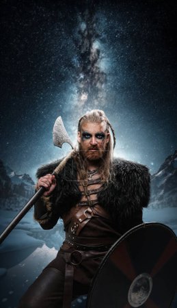 Art of scandinavian warrior from past with makeup against mountains and starry sky.