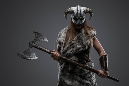 Photo for Shot of barbarian from north with fur and long hairs holding huge axe. - Royalty Free Image