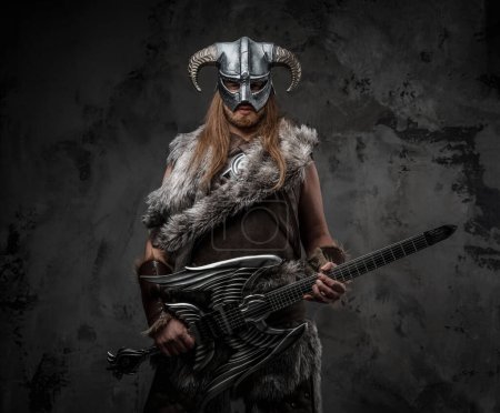 Foto de Estudio plano de escandinavo bárbaro con guitarra y casco con cuernos. - Imagen libre de derechos