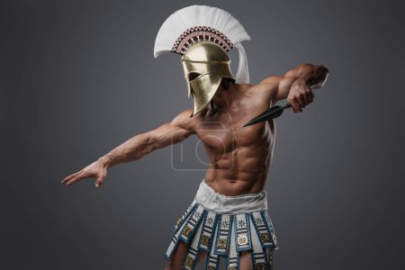 Téléchargez les photos : Prise de vue de guerrier topless de la Grèce avec un corps parfait sur fond gris. - en image libre de droit