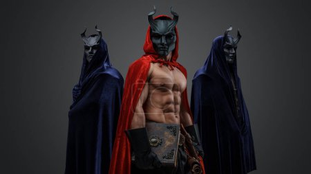 Studio shot of three esoteric followers of dark cult isolated on gray background.