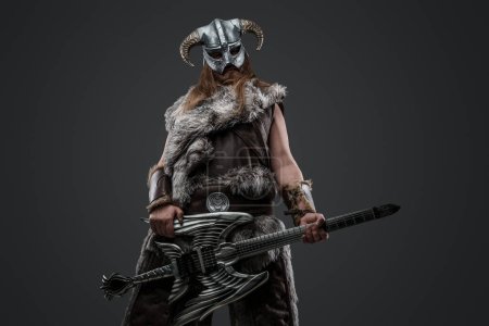 Foto de Retrato de guerrero escandinavo con guitarra eléctrica y casco con cuernos mirando a la cámara. - Imagen libre de derechos