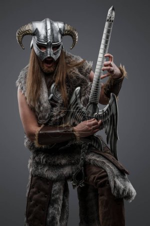 Foto de Tiro de guitarrista bárbaro del norte con pelos largos y guitarra eléctrica. - Imagen libre de derechos
