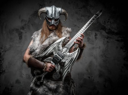 Photo for Studio shot of scandinavian barbarian with guitar and horned helmet. - Royalty Free Image
