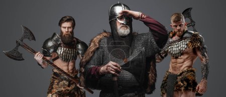 Photo for Portrait of antique vikings warriors with axes dressed in armor and fur. - Royalty Free Image