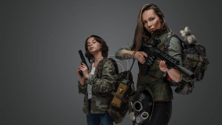 Foto de Estudio de tiro de la mujer post apocalíptica y chica joven sobre fondo gris. - Imagen libre de derechos