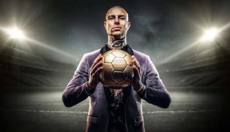 Foto de Arte de jugador de fútbol seguro vestido con un atuendo elegante celebración de la pelota de fútbol. - Imagen libre de derechos