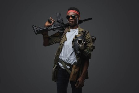 Photo for Studio shot of military man of african ethnic with red headband and rifle. - Royalty Free Image