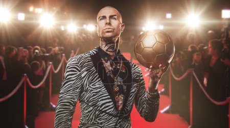 Foto de Arte de jugador de fútbol guapo vestido con traje de moda sosteniendo pelota de fútbol. - Imagen libre de derechos