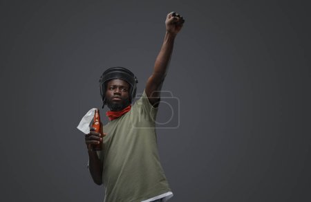 Photo for Shot of rebel man of african ethnic with helmet showing fist up sign. - Royalty Free Image